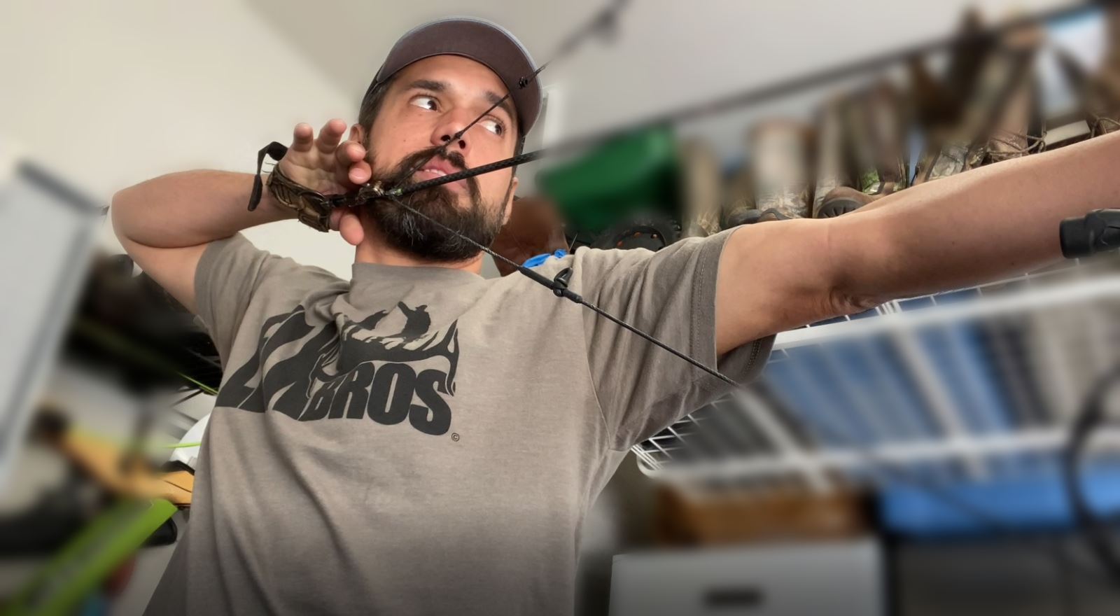 Luis drawing his bow in the shop